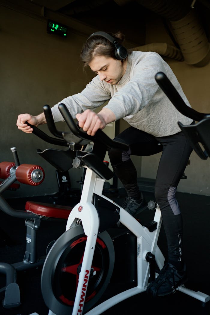 services-05 Young man focused on workout using exercise bike in gym